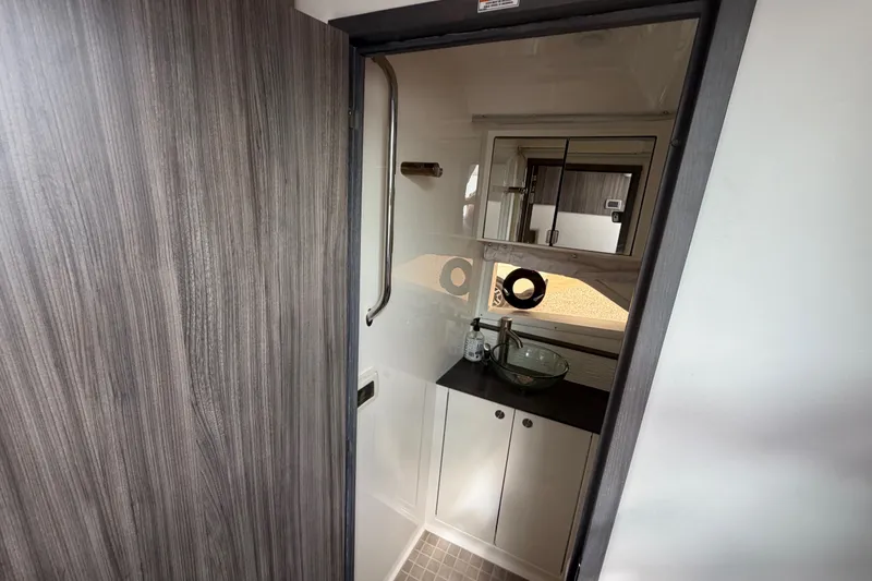 Slide: The Image of 2021 Sea Ray Sundancer 320 bathroom with modern sink, mirror, and wood accents. - 37