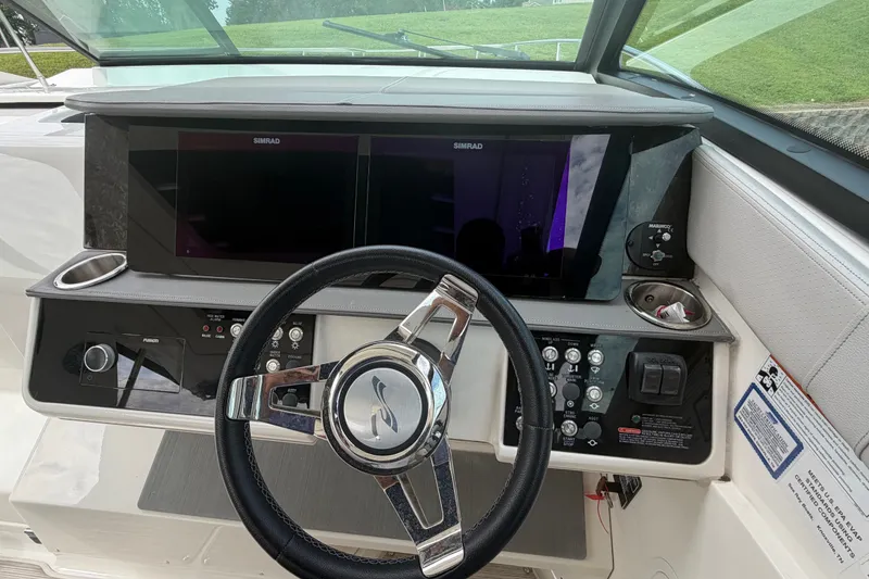 Slide: The Image of Cockpit of 2021 Sea Ray Sundancer 320 with modern navigation controls and steering wheel. - 19