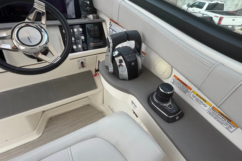 Slide: The Image of 2021 Sea Ray Sundancer 320 helm with steering wheel and control panel. - 21