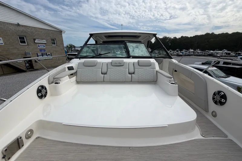 Slide: The Image of 2021 Sea Ray Sundancer 320 boat with spacious seating and modern design at a marina. - 45