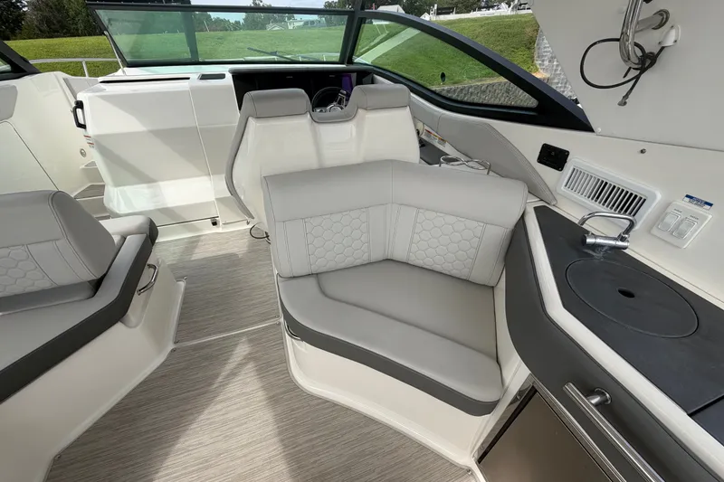 Slide: The Image of Interior of 2021 Sea Ray Sundancer 320, featuring modern seating and compact kitchenette. - 14