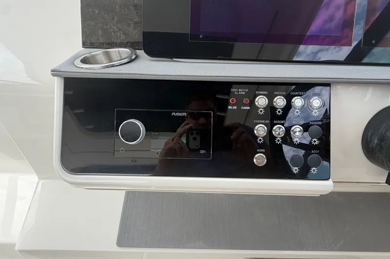 Slide: The Image of Control panel of a 2021 Sea Ray Sundancer 320 boat with various switches and a Fusion audio system. - 20
