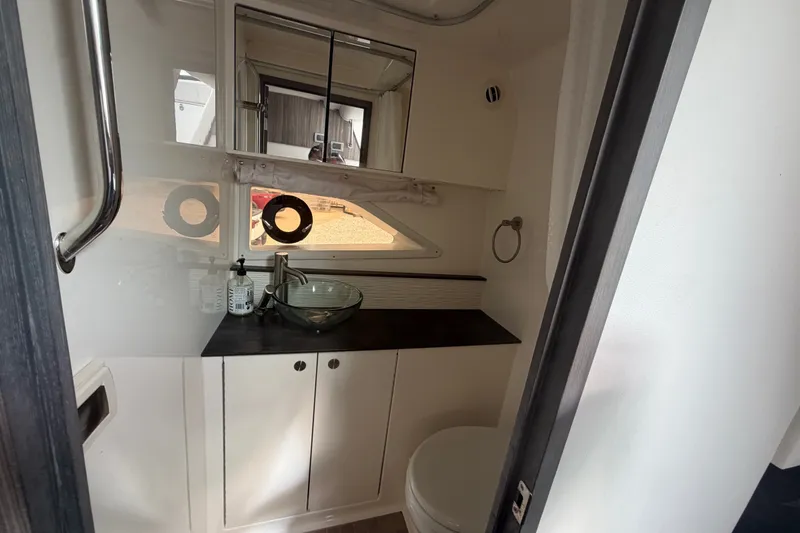 Slide: The Image of 2021 Sea Ray Sundancer 320 bathroom with modern sink, mirror, and storage cabinets. - 36