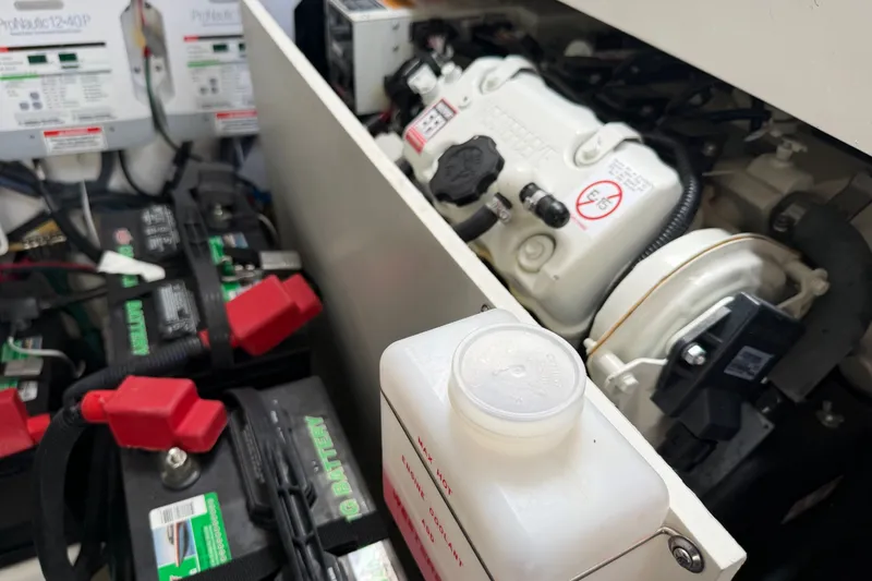 Slide: The Image of Engine compartment of 2021 Sea Ray Sundancer 320 with batteries and mechanical components. - 26