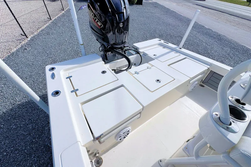 Slide: The Image of 2023 Pathfinder 2200 TRS boat deck with storage compartments and outboard motor. - 7
