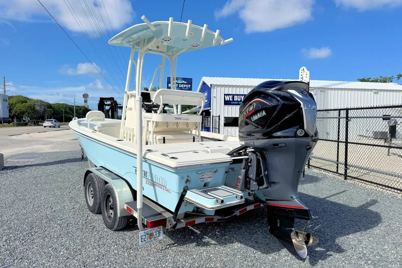 Slide: The Image of 2023 Pathfinder 2200 TRS boat with Yamaha engine on trailer, parked outdoors. - 2
