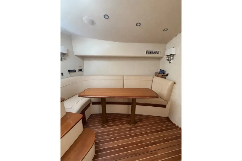 Slide: The Image of Interior of 2012 Viking 42 Open yacht with wooden table and cushioned seating. - 4