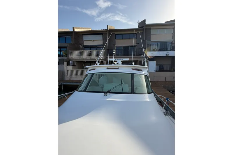 Slide: The Image of 2012 Viking 42 Open yacht docked near modern buildings under a clear sky. - 3