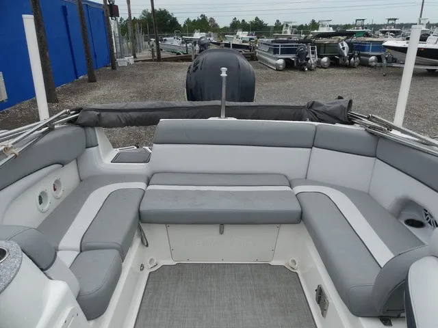 Slide: The Image of The image shows the cockpit of a 2023 NauticStar 243 DC with gray upholstery and an outboard motor. - 18