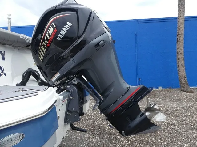 Slide: The Image of A Yamaha outboard motor is attached to a blue boat, resting on a gravel surface. - 10