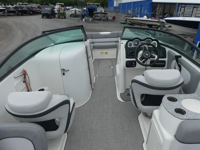 Slide: The Image of The image shows the cockpit of a 2023 NauticStar 243 DC boat with gray seating and a helm. - 12