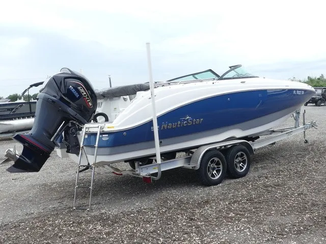Slide: The Image of A 2023 NauticStar 243 DC boat on a trailer with an outboard motor. - 5