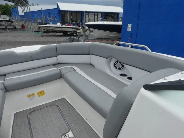 Slide: The Image of The image shows the gray and white seating area of a 2023 NauticStar 243 DC boat. - 14