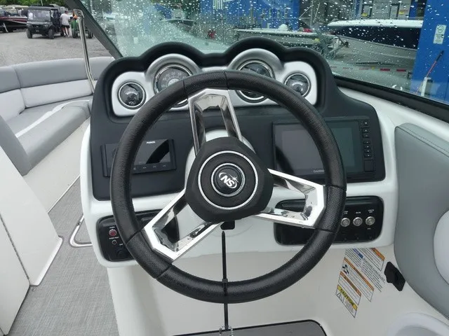 Slide: The Image of The image shows the helm of a 2023 NauticStar 243 DC boat with modern instruments. - 19