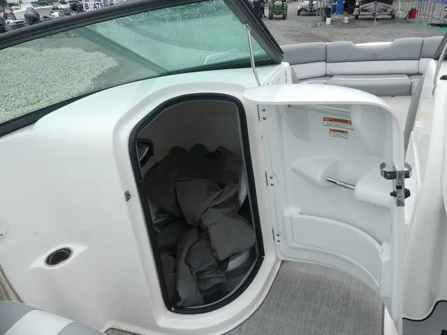 Slide: The Image of The image shows the interior of a 2023 NauticStar 243 DC boat with an open storage compartment. - 20
