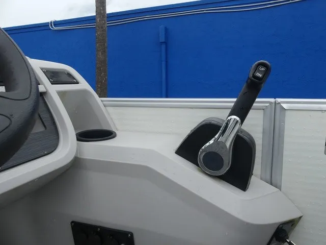 Slide: The Image of Close-up of a 2024 Sweetwater SW 2286 SB helm with throttle lever and cup holder. - 23