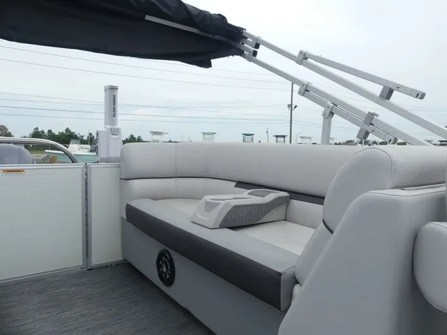 Slide: The Image of The image shows the rear of a Sweetwater SW 2286 SB pontoon boat with gray upholstery and a Bimini top. - 25