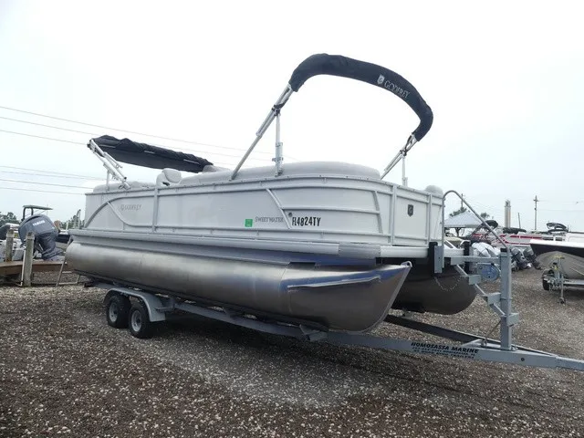 Slide: The Image of A 2024 Sweetwater SW 2286 SB pontoon boat on a trailer, featuring a black Bimini top. - 4