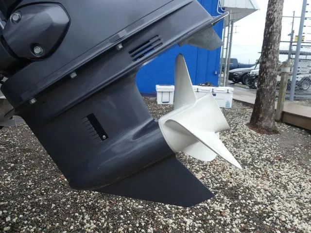 Slide: The Image of Close-up of a boat propeller on a gravel surface, with a blue wall in the background. - 11