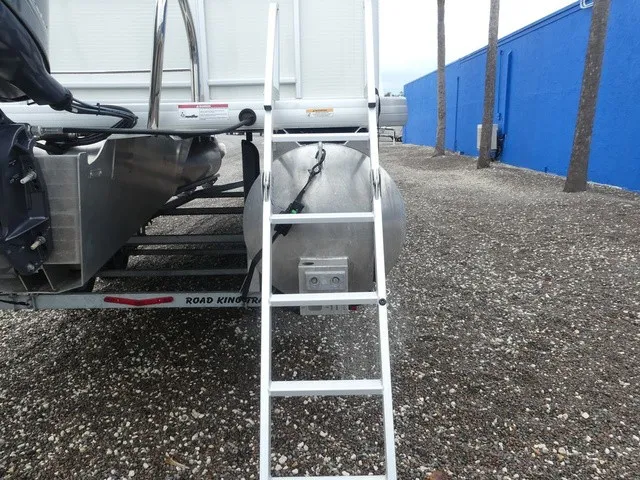 Slide: The Image of A ladder leads to a pontoon boat with a silver hull and a trailer. - 33