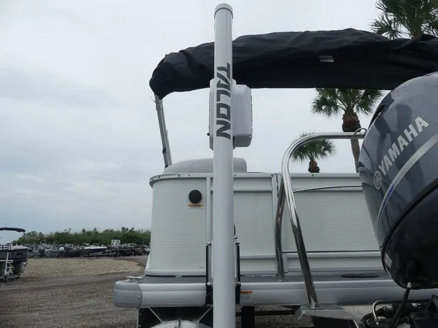 Slide: The Image of A 2024 Sweetwater SW 2286 SB pontoon boat with a Yamaha engine, parked on a gravel lot. - 14