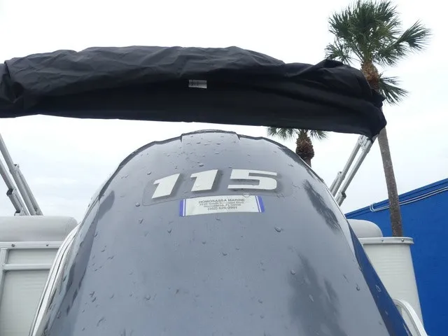 Slide: The Image of A Sweetwater SW 2286 SB boat with a 115 HP outboard motor, surrounded by palm trees. - 12