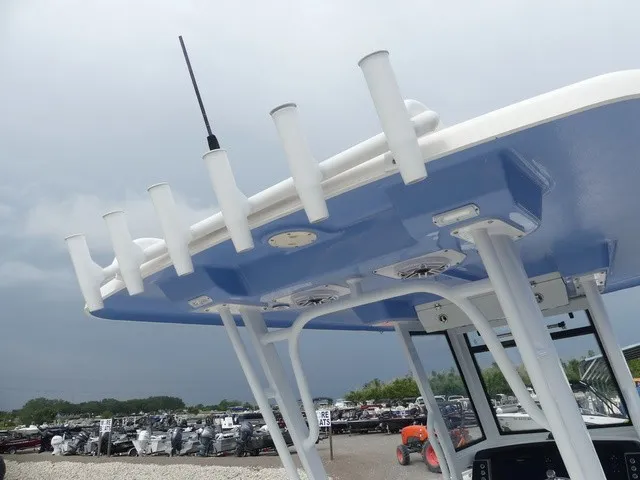 Slide: The Image of The image shows the T-top of a Robalo R272 Center Console boat with fishing rod holders. - 32