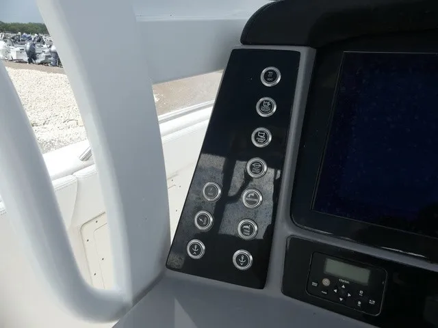 Slide: The Image of The image shows the dashboard of a 2022 Robalo R272 Center Console boat with multiple switches. - 24