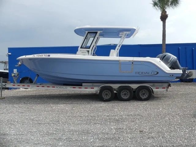 Slide: The Image of A 2022 Robalo R272 Center Console boat on a trailer, featuring a blue hull and T-top. - 7