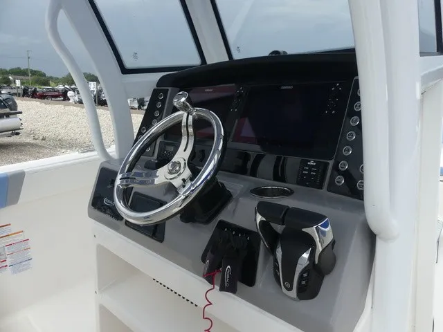 Slide: The Image of The image shows the helm of a 2022 Robalo R272 Center Console boat with modern instruments. - 26