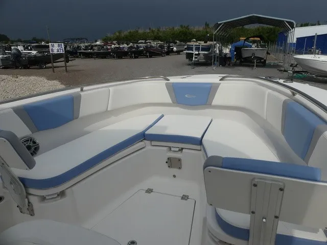 Slide: The Image of The image shows the bow seating area of a 2022 Robalo R272 Center Console boat with blue and white cushions. - 15