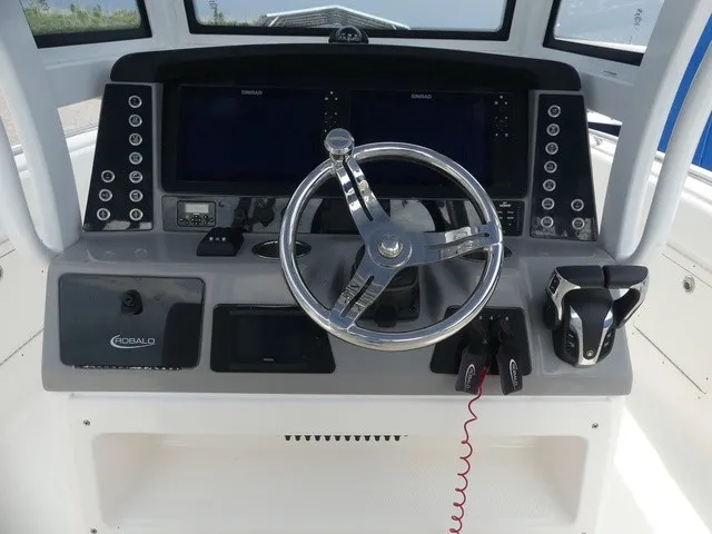 Slide: The Image of The image shows the helm of a 2022 Robalo R272 Center Console boat with modern instruments. - 18