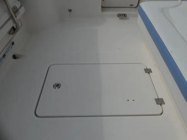Slide: The Image of The image shows a boat floor with a rectangular access hatch and blue upholstery. - 27