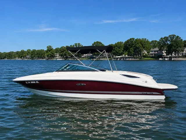 The Image of A 2013 Sea Ray SLX 230 on a calm lake with trees in the background. - 1