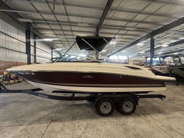 Slide: The Image of A 2013 Sea Ray SLX 230 sits on a trailer in a warehouse. - 5