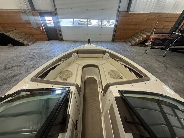 Slide: The Image of The image shows the bow of a 2013 Sea Ray SLX 230 boat inside a warehouse. - 15