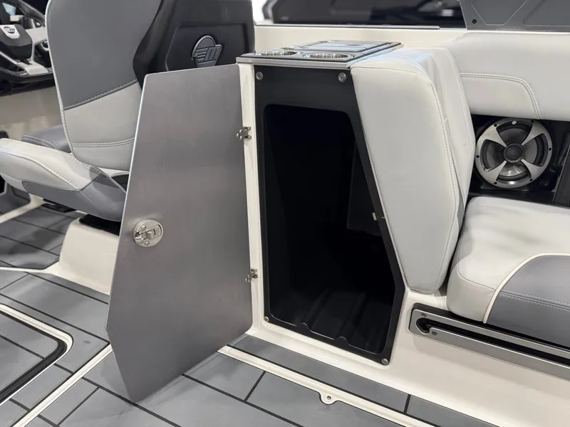 Slide: The Image of The 2021 Malibu Wakesetter 24 MXZ features an open storage compartment next to a seat. - 19