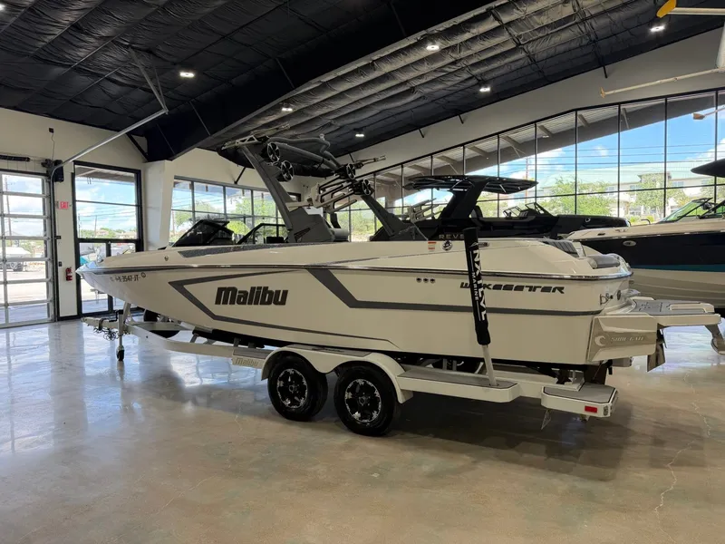 Slide: The Image of A white 2021 Malibu Wakesetter 24 MXZ boat on a trailer in a showroom. - 5