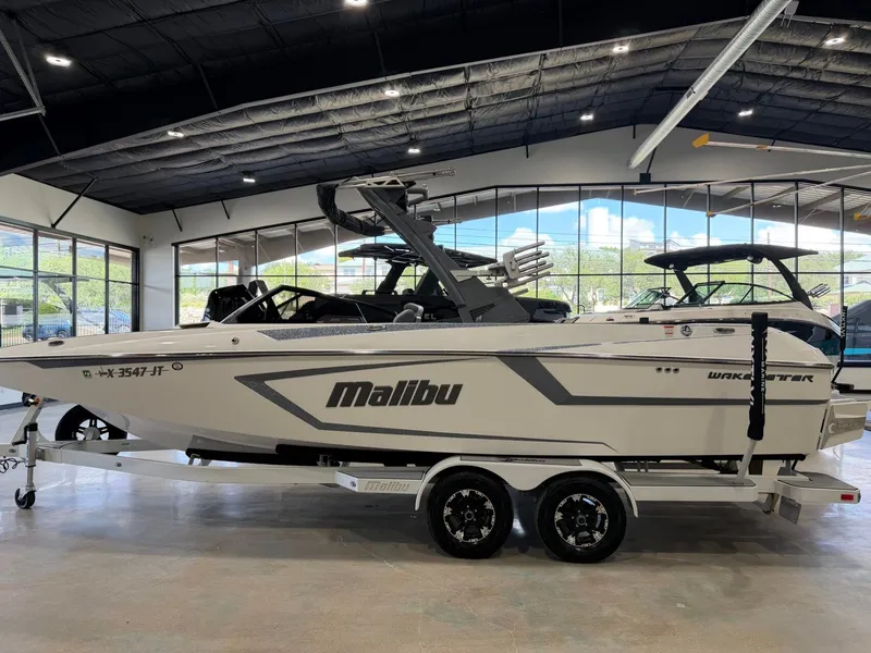 Slide: The Image of A 2021 Malibu Wakesetter 24 MXZ boat on a trailer in a showroom. - 6