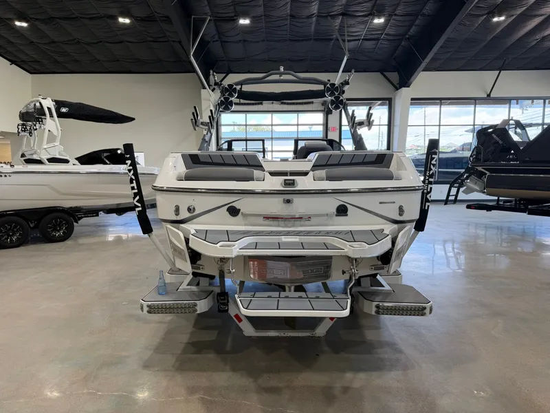 Slide: The Image of The image shows the rear of a 2021 Malibu Wakesetter 24 MXZ in a showroom. - 4