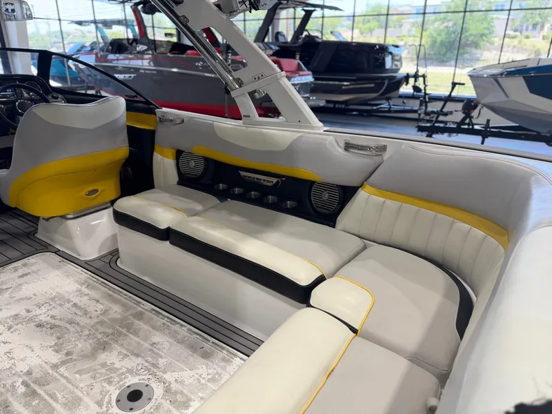 Slide: The Image of The image shows the interior of a 2014 Malibu Wakesetter 24 MXZ with white and yellow seating. - 13