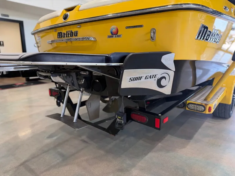 Slide: The Image of The image shows the rear of a yellow 2014 Malibu Wakesetter 24 MXZ with Surf Gate. - 4