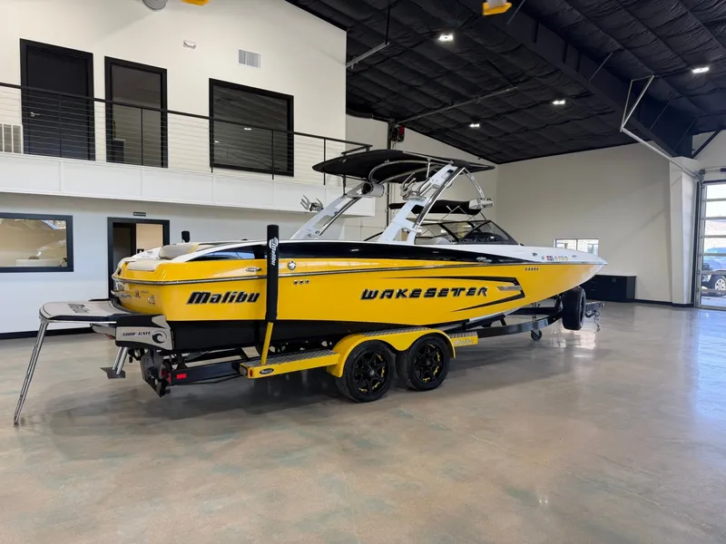 Slide: The Image of 2014 Malibu Wakesetter 24 MXZ in yellow and black inside a showroom. - 3
