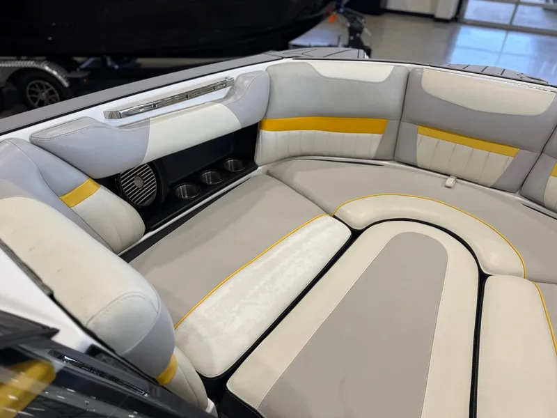 Slide: The Image of The interior of the 2014 Malibu Wakesetter 24 MXZ features cushioned seats in gray, white, and yellow. - 24