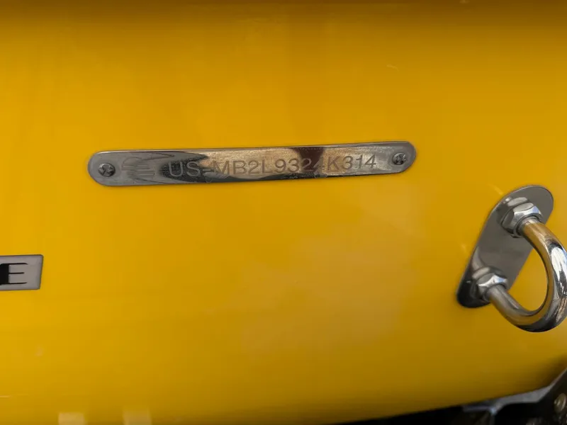 Slide: The Image of Close-up of a yellow boat hull with a metal plaque and a serial number. - 29