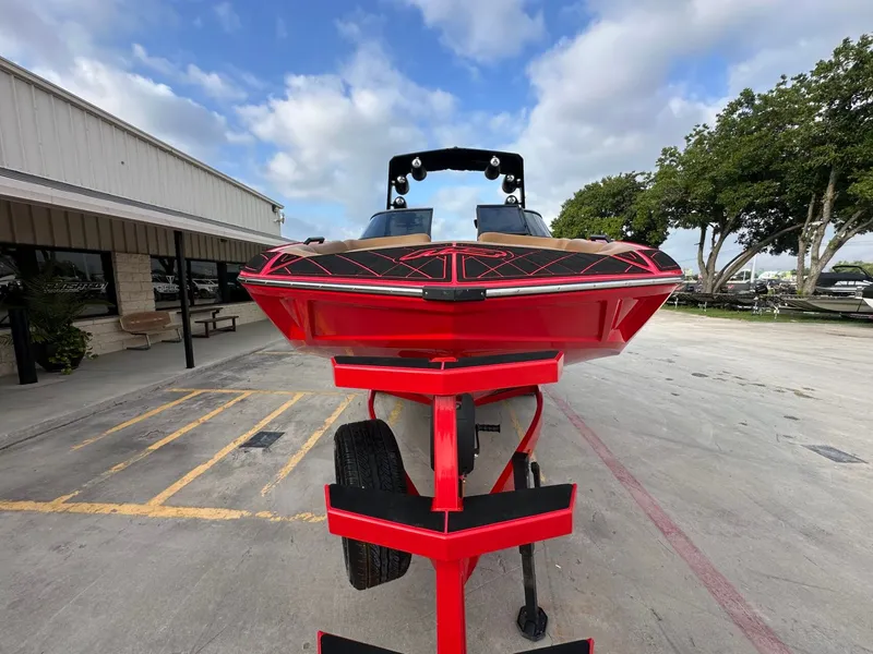 Slide: The Image of A red 2023 MB SPORTS B52 boat is on a trailer in an outdoor area. - 9