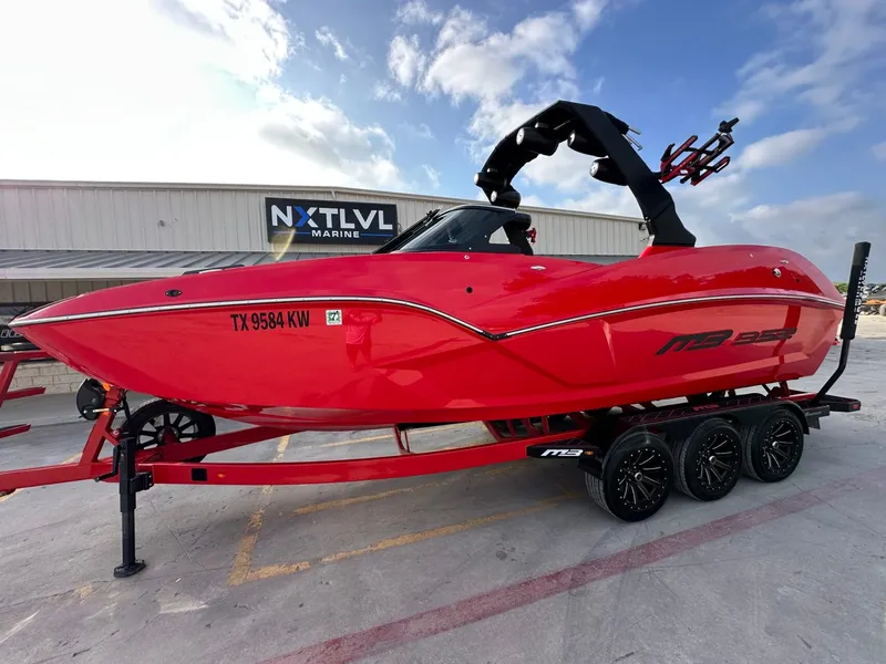 The Image of A red 2023 MB SPORTS B52 boat on a trailer in front of a building. - 1