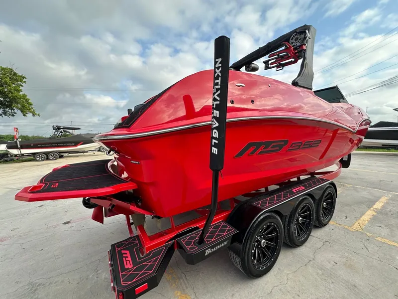 Slide: The Image of A red 2023 MB SPORTS B52 boat on a trailer, featuring sleek design and black accents. - 6