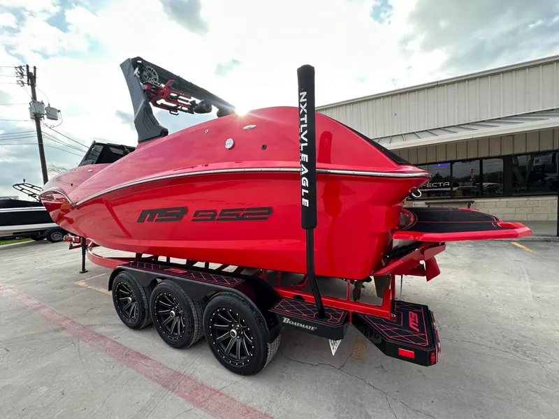 Slide: The Image of A red 2023 MB SPORTS B52 boat on a trailer, ready for transport. - 3