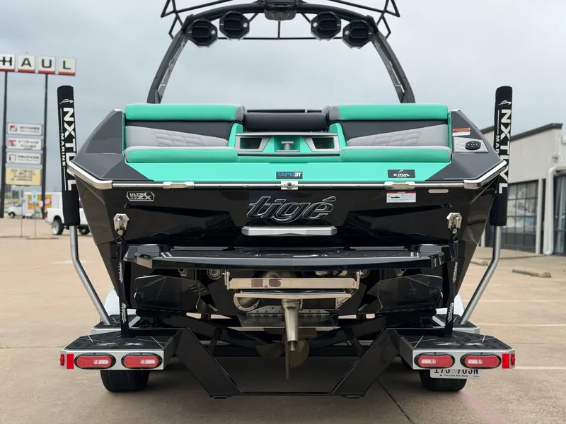Slide: The Image of The image shows the rear of a 2025 Tigé Ultré 23ZX boat with turquoise accents. - 4